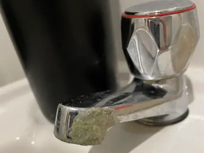 Basin tap with limescale damage to the spout